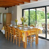 L'espace salle à manger et sa grande table devant la terrasse